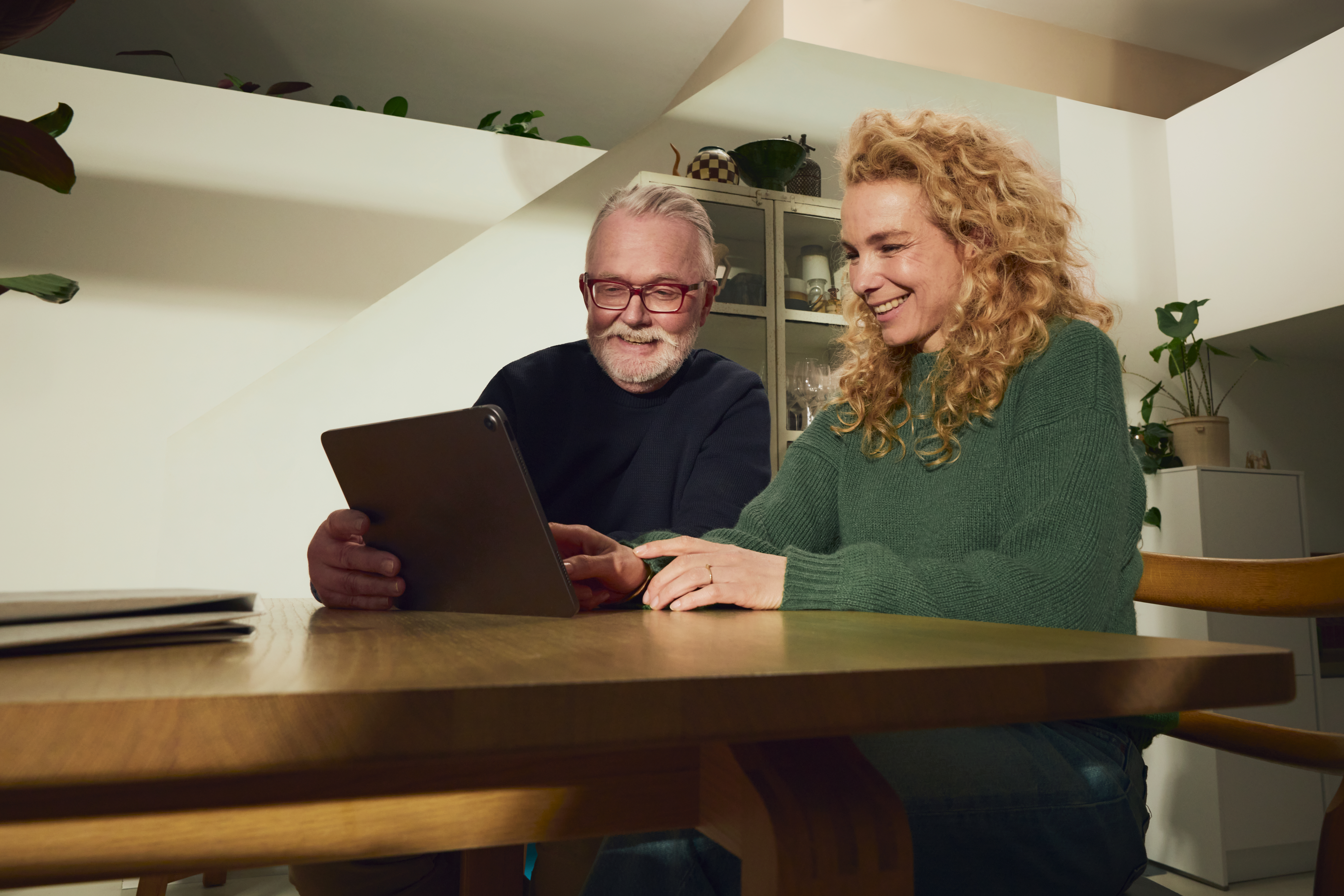 vader en dochter aan eettafel met tablet